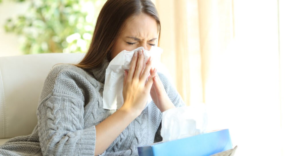 Woman blowing with flu in winter