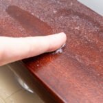 A finger swiping dust from furniture, dusty home concept