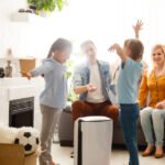 air purifier in living room with happy family moving to new apartment