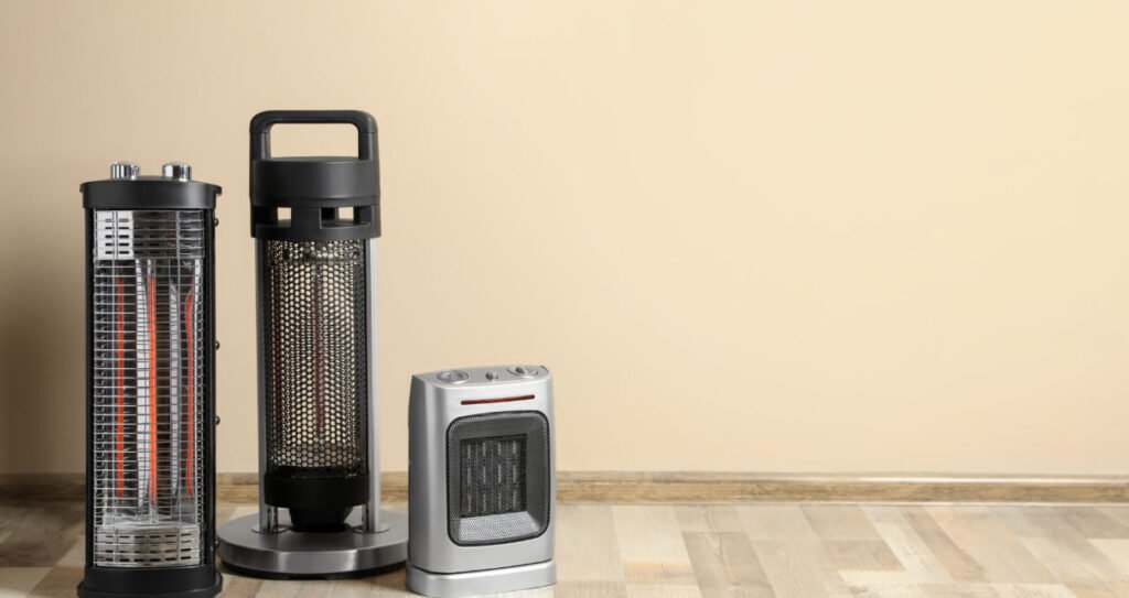 Different modern electric heaters on floor in room,