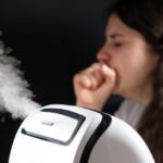 Humidifier and coughing woman in the background. Humidification of the air with cough and viral infections