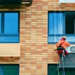 Industrial-climber-installs-air conditioning on the facade of an apartment building