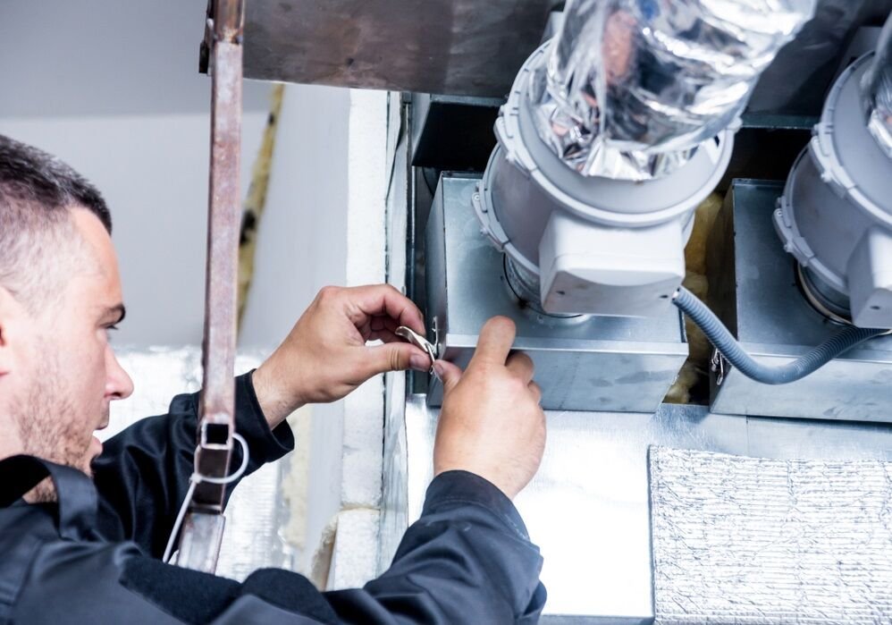man reparing ac duct