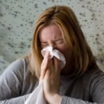 woman sneezing from mold allergy