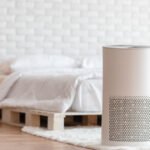Air purifier in cozy white bedroom for filter and cleaning remove